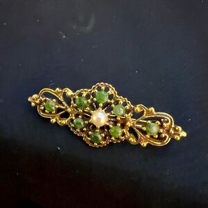 Cute pin with small peridot stones.